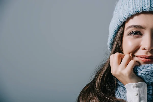 Glückliches Mädchen posiert in Strickmütze und Schal, isoliert auf grau — Stockfoto