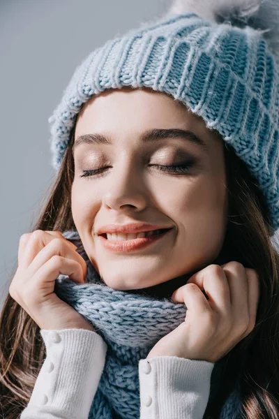 Bela mulher sonhadora posando com olhos fechados em chapéu de malha e cachecol, isolado em cinza — Fotografia de Stock