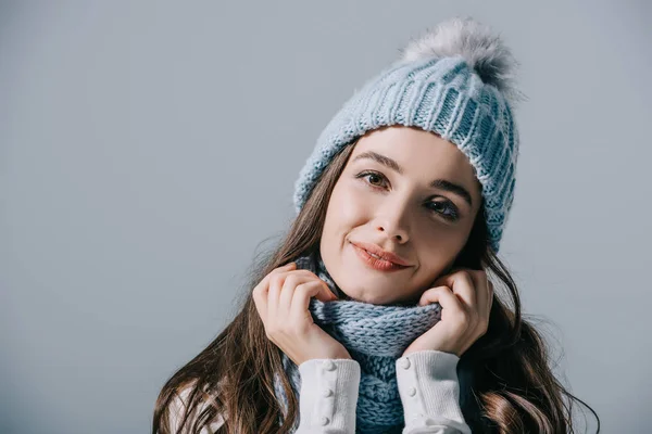 Hermosa mujer sonriente posando en sombrero de punto y bufanda, aislado en gris - foto de stock