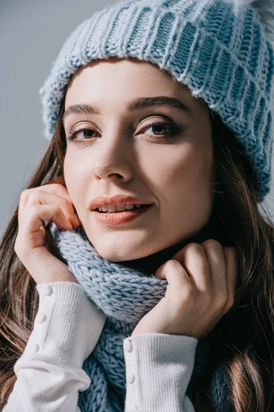 Beautiful woman posing in knitted hat and scarf, isolated on grey — Stock Photo