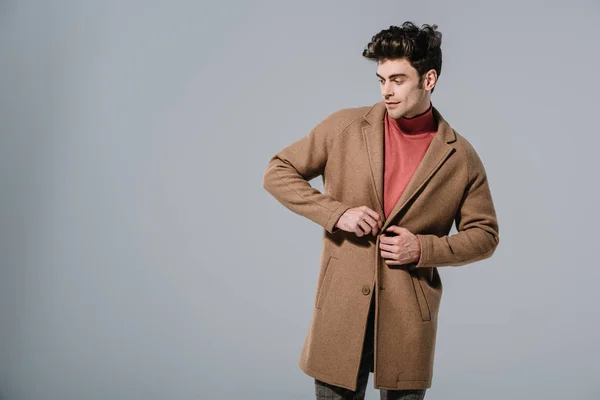 Uomo alla moda in posa in cappotto alla moda, isolato sul grigio — Foto stock