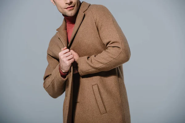 Abgeschnittene Ansicht eines modischen Mannes, der in beigem Mantel posiert, isoliert auf grau — Stockfoto