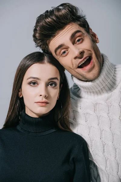 Portrait of fashionable beautiful couple posing in trendy sweaters, isolated on grey — Stock Photo