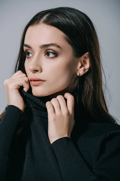 Menina elegante atraente posando em camisola preta, isolado em cinza — Fotografia de Stock