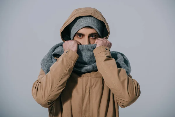 Handsome man posing in winter hat, scarf and coat, isolated on grey — Stock Photo