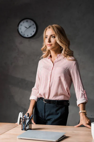 Attraente e bionda donna d'affari in camicia rosa guardando altrove — Foto stock