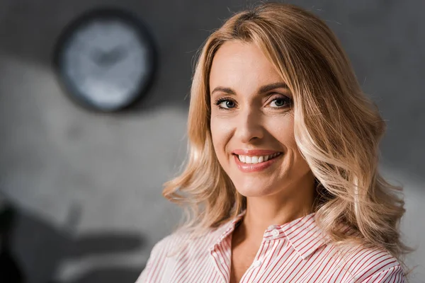 Attraktive Geschäftsfrau im rosa Hemd lächelt und blickt in die Kamera — Stockfoto