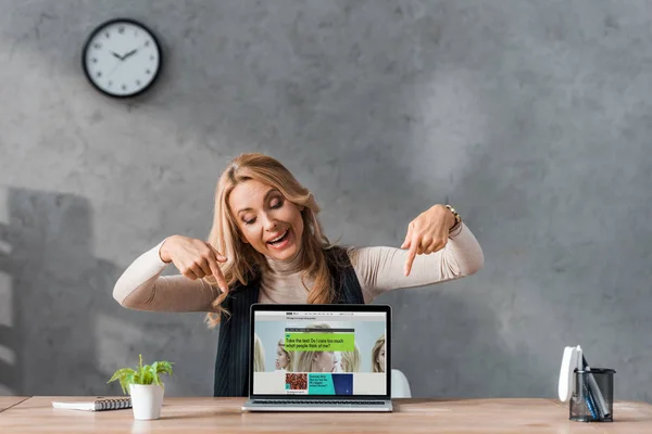 KYIV, UKRAINE - AUGUST 16, 2019: smiling businesswoman pointing with fingers at laptop with bbc website — Stock Photo