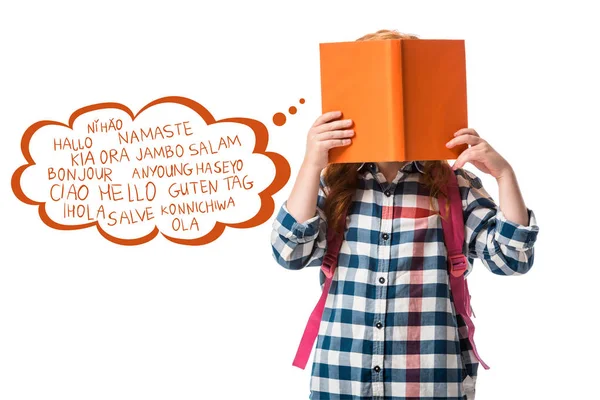 Pupil covering face with orange book near greeting lettering on white — Stock Photo