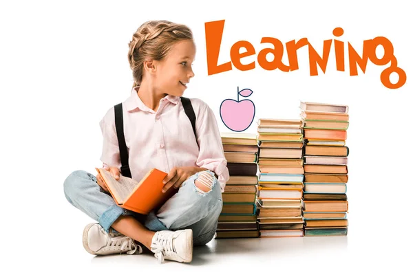 Niño feliz sosteniendo libro cerca de aprender letras en blanco - foto de stock