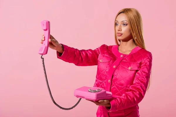 Mujer afroamericana elegante sosteniendo el teléfono aislado en rosa, concepto de muñeca de moda - foto de stock