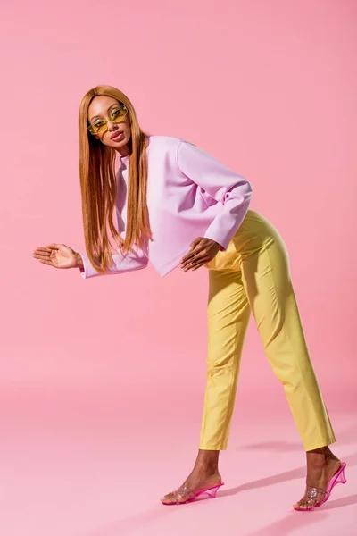 Elegante, mulher americana africana loira pisando em fundo rosa, conceito de boneca de moda — Fotografia de Stock
