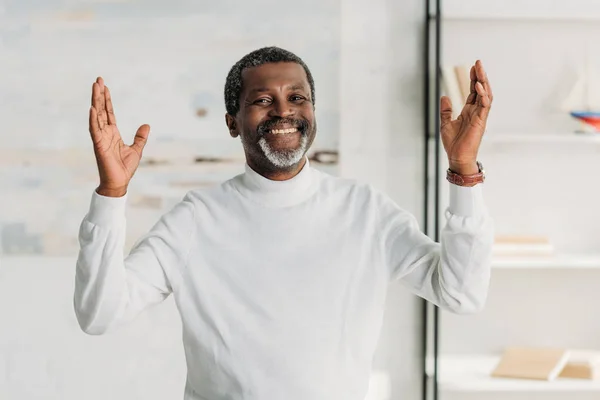 Feliz africano americano hombre mostrando wow gesto y sonriendo a la cámara - foto de stock