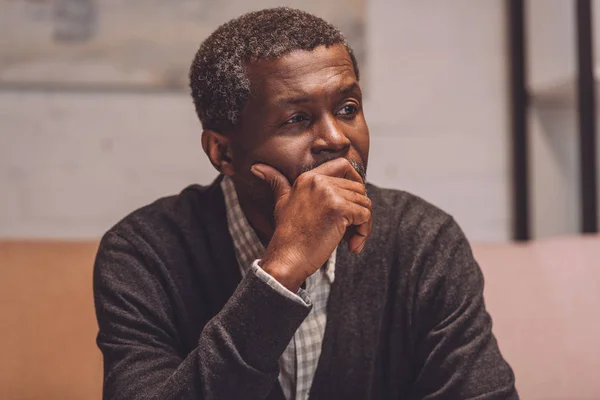 Depressiver afrikanisch-amerikanischer Mann schaut weg, während er die Hand vor das Gesicht hält — Stockfoto