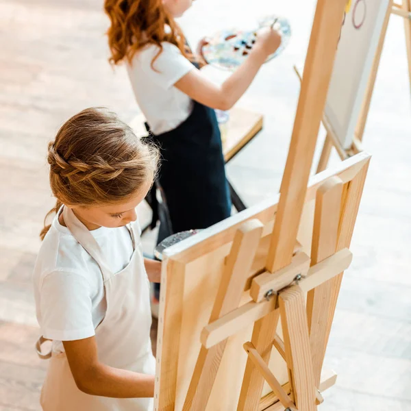 Foco seletivo da pintura infantil perto da criança na escola de arte — Fotografia de Stock
