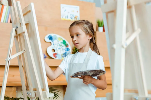 Selective focus of cute child painting in art school — Stock Photo