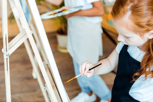Селективное внимание очаровательных детей, рисующих на холсте — стоковое фото