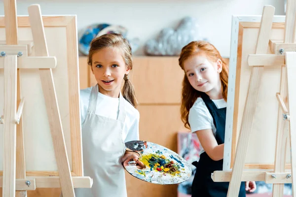 Selektiver Fokus entzückender Kinder, die in der Nähe von Staffeleien stehen — Stockfoto