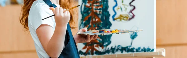 Plano panorámico de la pintura infantil sobre lienzo en la escuela de arte - foto de stock
