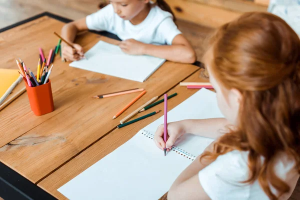 Selective focus of redhead kid drawing with cute child — Stock Photo