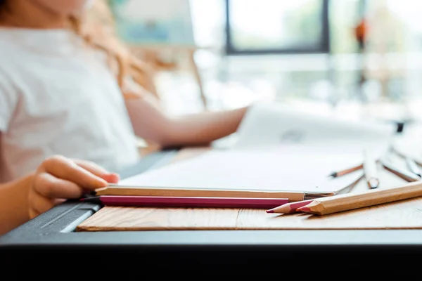 Selective focus of color pencils near child — Stock Photo