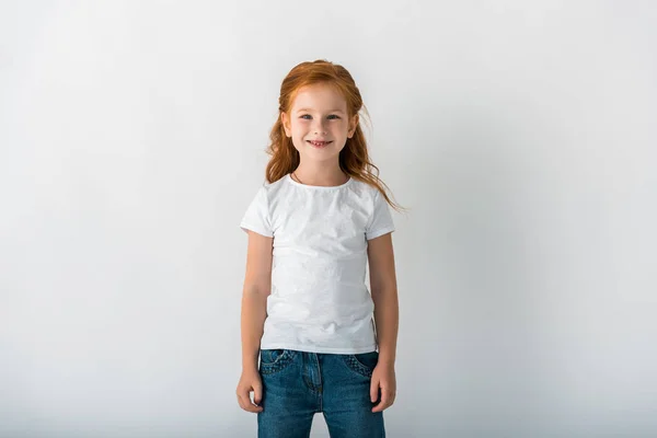 Smiling redhead child looking at camera on white — Stock Photo