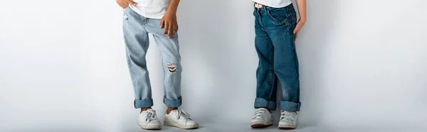 Colpo panoramico di bambini in jeans di jeans in piedi su bianco — Foto stock