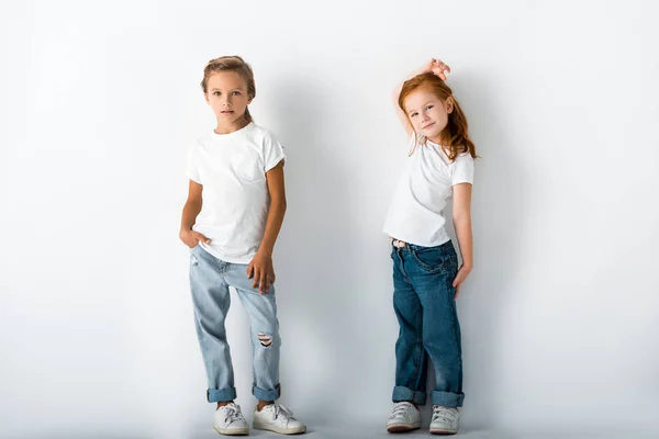 Cute kids in denim jeans standing on white — Stock Photo