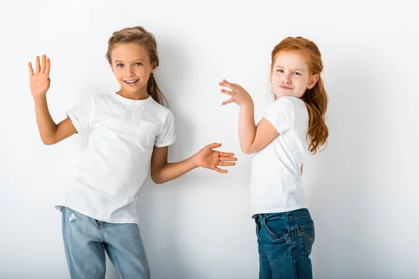 Entzückende Kinder lächeln und gestikulieren auf weiß — Stockfoto