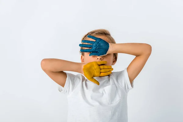 Niño con pintura en las manos cubriendo la cara aislada en blanco - foto de stock