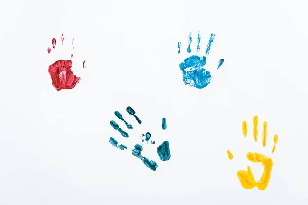 Impresiones de mano amarillas, azules y rojas sobre blanco - foto de stock