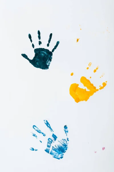 Gelbe, hellblaue und dunkelblaue Handabdrücke auf Weiß — Stockfoto