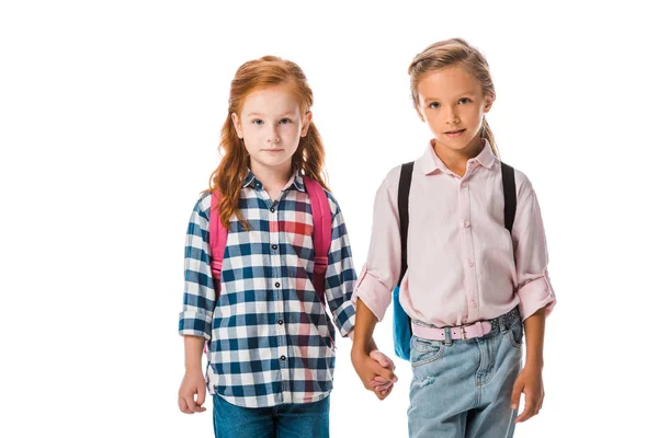 Cute schoolkids with backpack holding hands isolated on white — Stock Photo