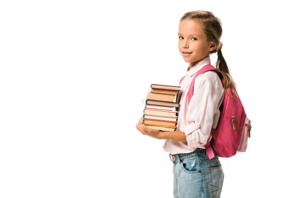 Adorable élève souriant tout en tenant des livres colorés isolés sur blanc — Photo de stock