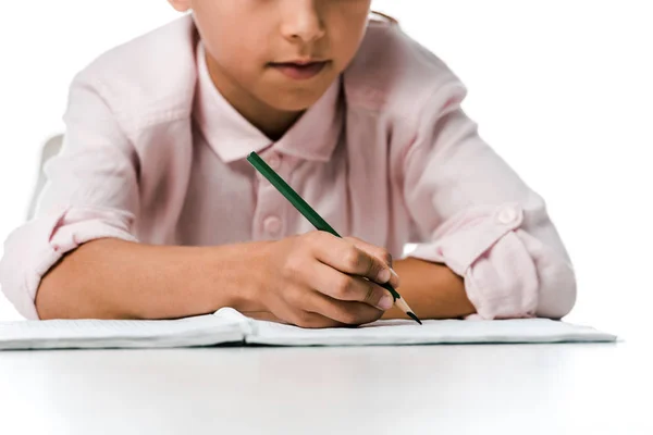 Обрізаний вид шкільного малюка, що тримає олівець біля блокнота на білому — Stock Photo
