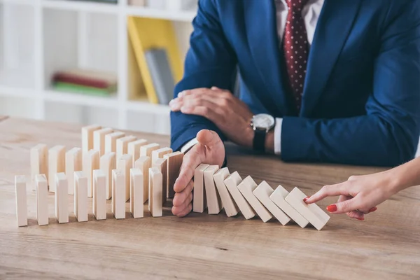 Vista recortada de la mujer empujando bloque de madera y gestor de riesgos detener efecto dominó — Stock Photo