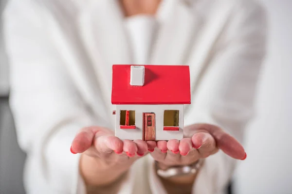 Partial view of businesswoman showing house model — Stock Photo