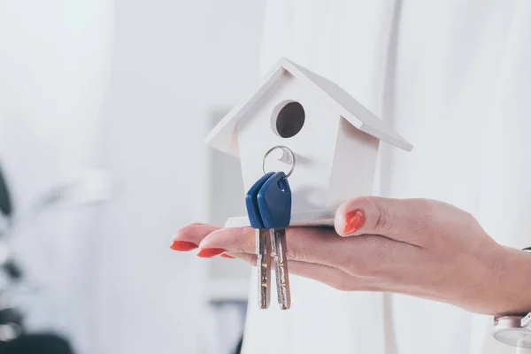 Vista parziale della donna d'affari che tiene il modello della casa con le chiavi — Foto stock