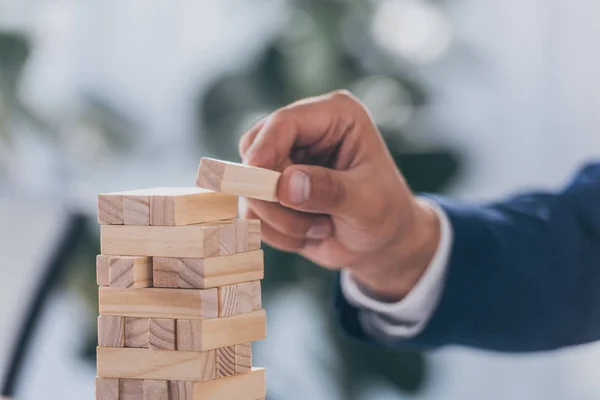 Abgeschnittene Ansicht eines Geschäftsmannes, der Holzklötze auf Stapel legt — Stockfoto