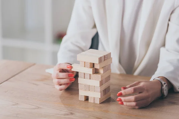 Vue recadrée de femme d'affaires prenant bloc de bois de la pile — Photo de stock