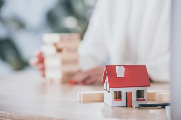 Foco seletivo do modelo de casa perto do gerente de risco e blocos de madeira — Fotografia de Stock