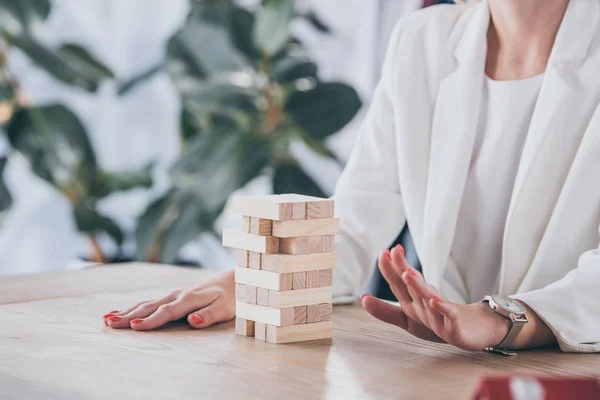 Cropped view of risk manager sitting at desk near stacked wooden blocks — Stock Photo