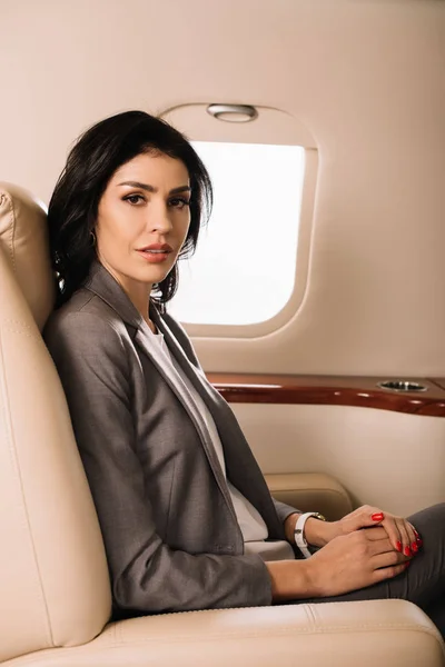 Hermosa mujer de negocios sentada en jet privado - foto de stock