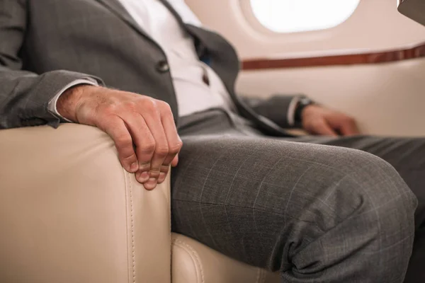 Vue recadrée d'un homme d'affaires assis dans un jet privé — Photo de stock