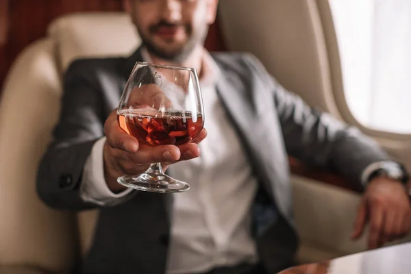 Foyer sélectif de verre avec cognac en main sur l'homme d'affaires — Photo de stock