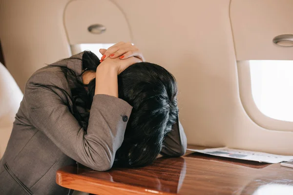 Mujer de negocios con miedo de vuelo sentado en jet privado - foto de stock