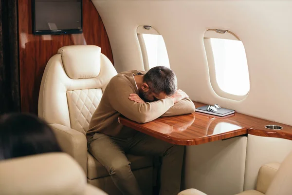 Foyer sélectif de l'homme couvrant le visage tout en étant assis dans la première classe de jet privé — Photo de stock