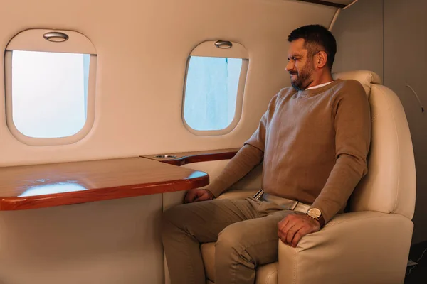 Наляканий чоловік із закритими очима сидить у приватному літаку — стокове фото