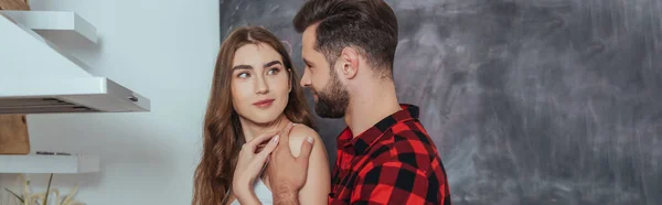 Panoramic shot of young man touching shoulder of smiling girlfriend — Stock Photo