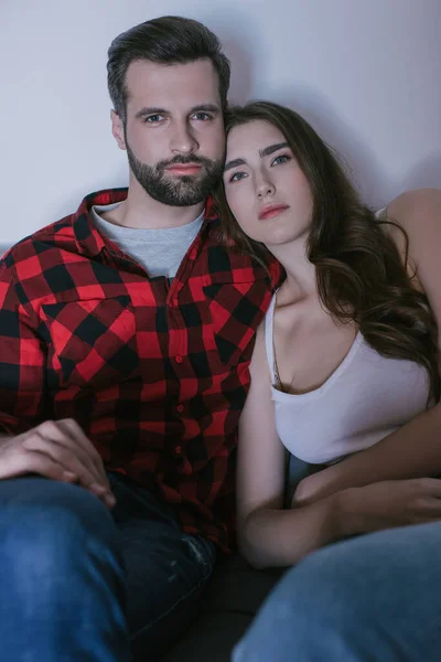 Sérieux, attentif jeune couple regarder la télévision à la maison — Photo de stock